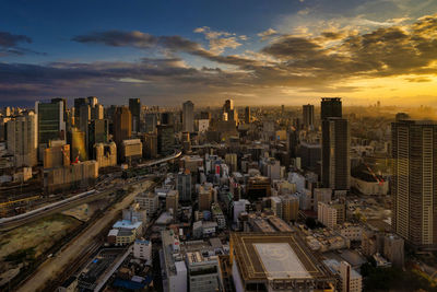 Aerial view of buildings against cloudy sky during sunset