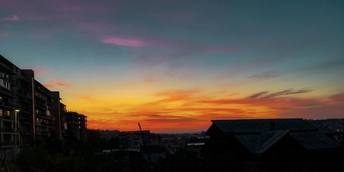 Silhouette buildings against sky at sunset