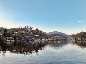 River by townscape against sky