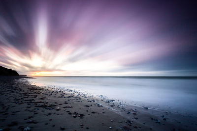 Scenic view of beach against sky during sunset