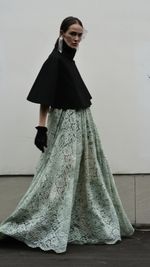 Portrait of young woman standing against wall