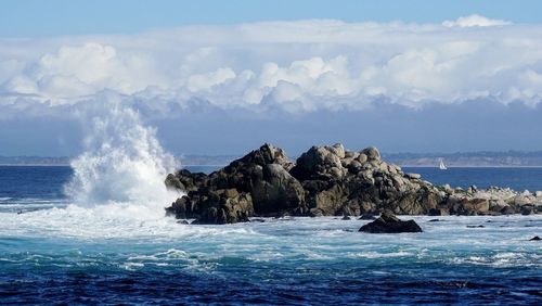 Scenic view of rocks in sea against sky