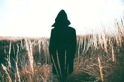 Rear view of silhouette man on field against clear sky