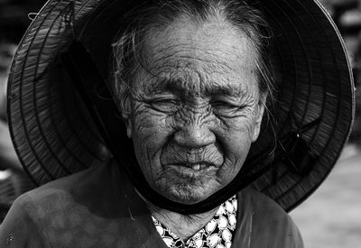 Close-up portrait of senior woman wearing asian style conical hat