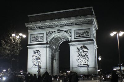 People on illuminated building at night