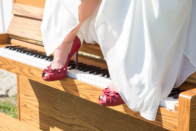 Low section of woman standing piano