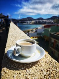 Close-up of coffee cup against sky