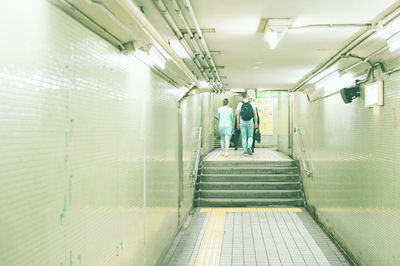 Rear view of people walking in illuminated building
