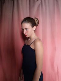 Young woman standing against wall