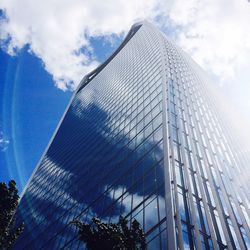 Low angle view of modern building against cloudy sky