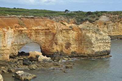 Rock formations by sea against sky