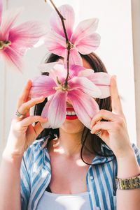 Portrait of woman holding pink flower