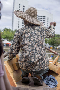 Rear view of woman standing by hat in city