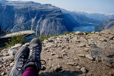 Low section of person relaxing on rock