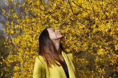 Portrait of woman looking away on tree during spring