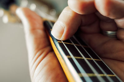 Cropped hand of man playing guitar