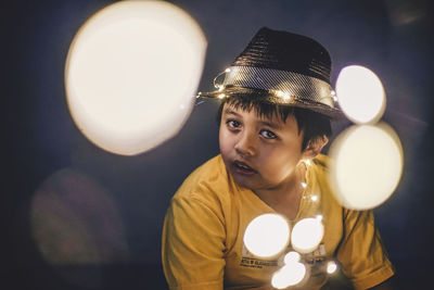 Portrait of boy amidst illuminated lights