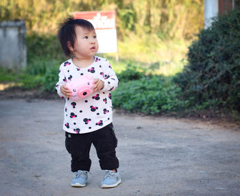 Portrait of boy standing on footpath