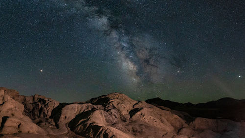 Scenic view of rock formation against sky at night