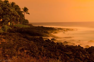 Scenic view of sea against orange sky