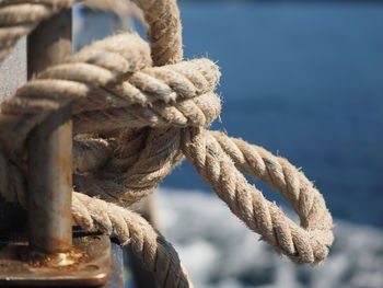 Close-up of rope tied to moored on sea