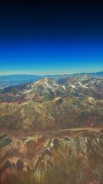 Aerial view of dramatic landscape against clear blue sky