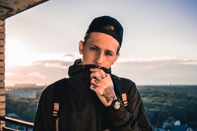 Portrait of young man standing against sky