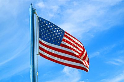 Low angle view of american flag against blue sky