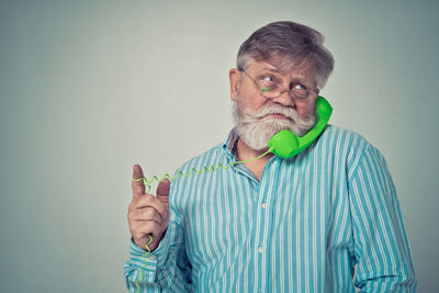 Portrait of man standing against gray background