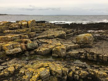 Rocks on beach against sky