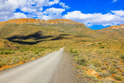 Road amidst mountains against sky