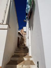 Low angle view of staircase amidst buildings against sky