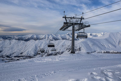 Snow covered mountain against sky with ski lift