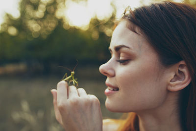 Close-up portrait of young woman holding plant