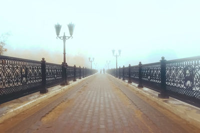 Street lights on bridge against sky