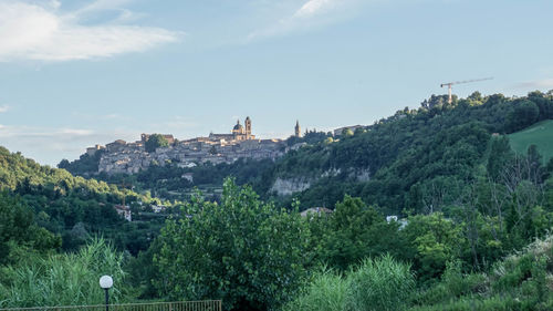 Panoramic view of trees and buildings against sky