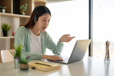 Businesswoman using laptop at table