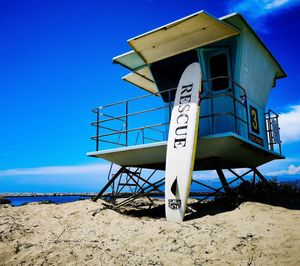 Lifeguard hut on beach against clear blue sky