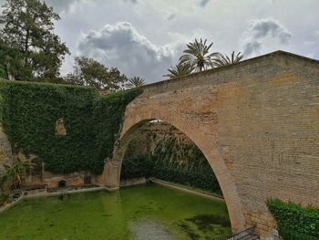 Arch bridge over canal against sky