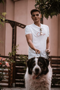 Portrait of man with dog standing outdoors