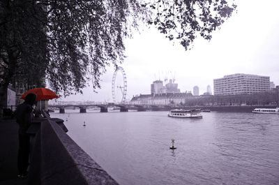 Scenic view of river in city against sky