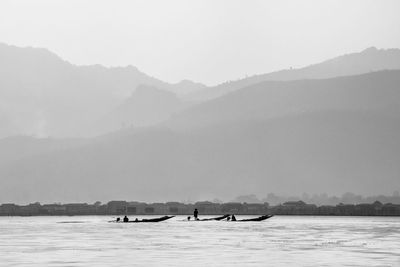 Scenic view of boats moored at lake against sky