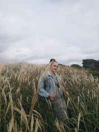 Woman standing on field against sky