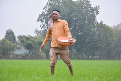 Full length of man holding umbrella on field