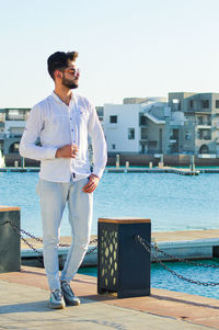 Portrait of young man standing against clear sky