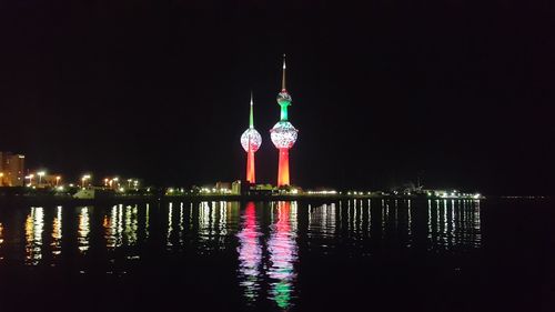 Reflection of illuminated clock tower in water at night