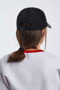 Rear view of woman wearing hat against white background