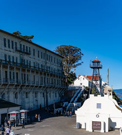 Buildings in city against clear blue sky