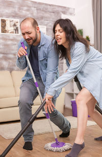 Happy young couple holding hands on floor