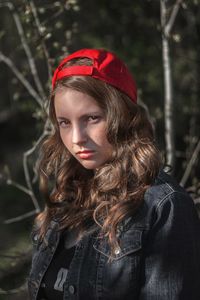 Close-up portrait of young woman wearing red cap